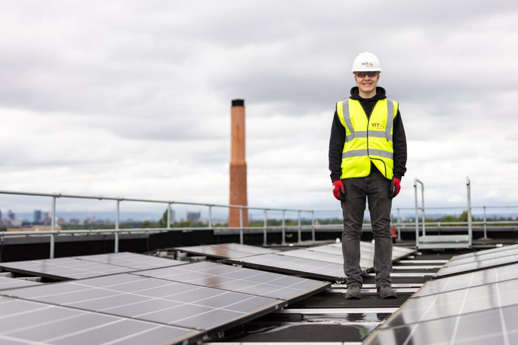 Engineer Standing among Solar Panels